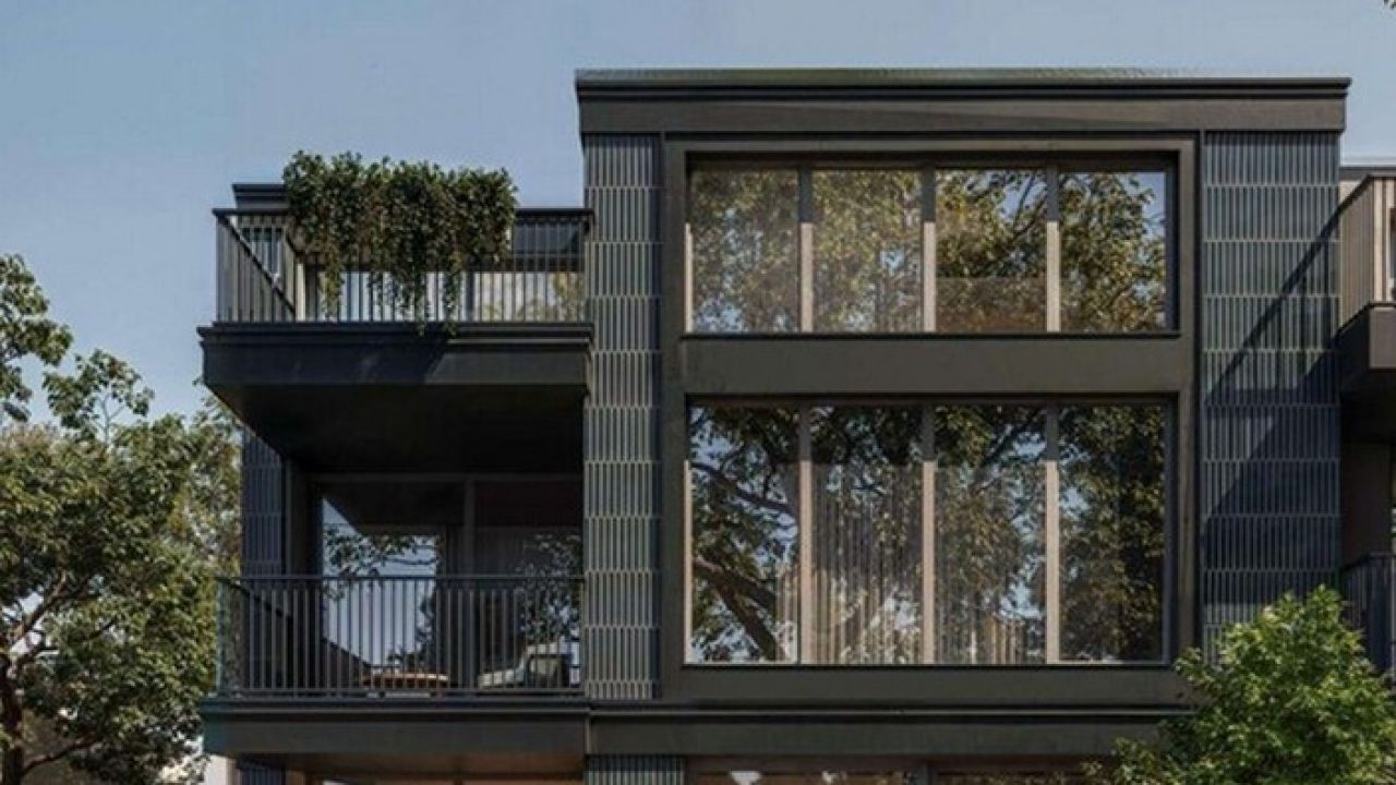 Візуалізація триповерхового житлового будинку з сучасним фасадом темного кольору з відкритими балконами та великими панорамними вікнами